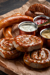 Round fried sausages with ketchup on paper. Bavarian grilled sausages