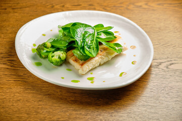 Pike perch fish fillet with spinach leaves