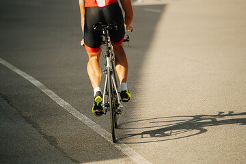 Legs of a man riding his street racing bike on a road through