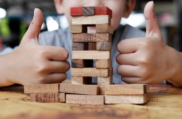 wooden sticks are arranged in a row with a child's hand.