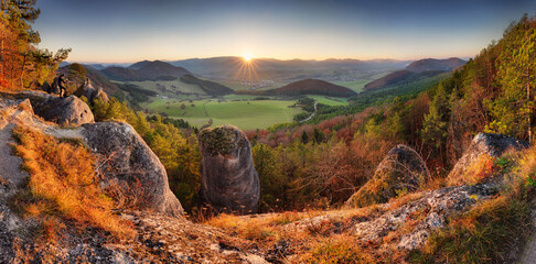 Scenic landscape in Sulov, Slovakia, on beautiful autumn sunrise with colorful leaves on trees in forest and bizarre pointy rocks on mountains valleys.