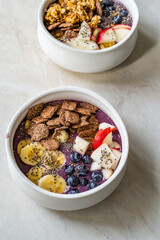 Smoothie Bowl with Granola, Cereal Grains, Chia Seeds, Apple and Blueberries.