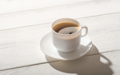 espresso coffee in a white classic cup on rustic wooden table. good morning, natural sunlight.