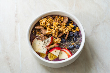 Smoothie Bowl with Granola, Cereal Grains, Chia Seeds, Apple and Blueberries.