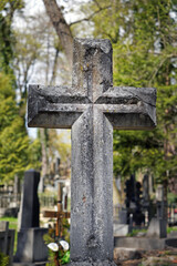 Grave on traditional European cemetery. Aged crosses tomb stone on grave yard.