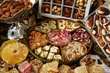 Eastern sweets with nuts, candy, dates in box background,