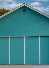 Vertical White puffy clouds Aqua blue detached garage exterior at Oceanside, California