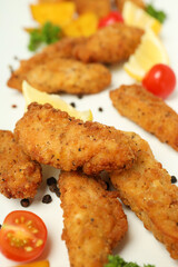 Concept of tasty food with chicken strips on white background