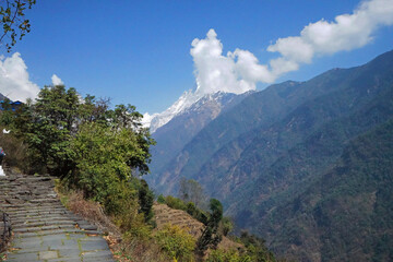 Rocky steps and wooden bridge to Machapuchare base camp with landscape of snowcapped mountain view- the local village along trekking to Annapurna Himalayan range- Nepal