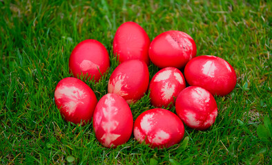 Red painted Easter eggs on green grass. Beautiful orthodox and catholic Easter decorations.