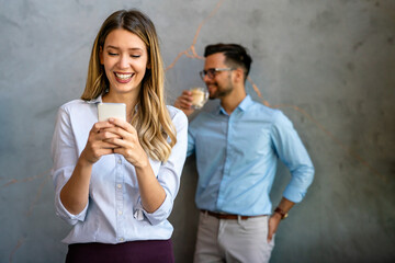 Happy businesswoman using mobile phone while analyzing weekly schedule in corporate office
