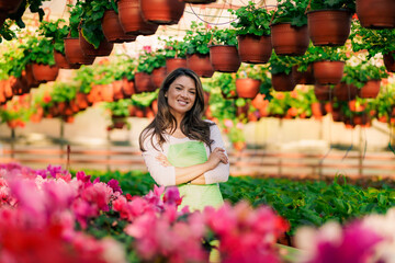Fototapeta premium Portrait of a beautiful Caucasian woman in a working environment of a flower greenhouse.