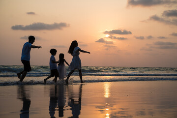 Family walking and playing at beach sunset with kids happy vacation concept