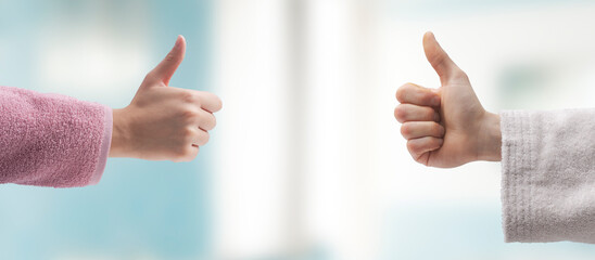 Man and woman in bathrobe giving a thumbs up