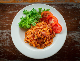 Spaghetti with ketchup on wooden floor ready to serve.
