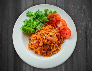 Spaghetti with ketchup on wooden floor ready to serve.