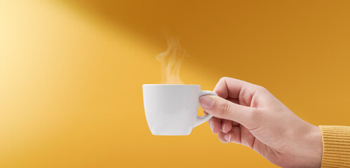 Hand holding a cup of coffee