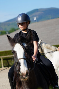 young girl on horseback in an equestrian center