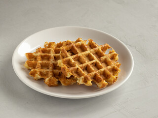 Cabbage waffles with cheese on the white plate