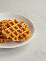 Cabbage waffles with cheese on the white plate