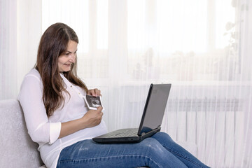 a pregnant woman shows an ultrasound image of an unborn child via video link