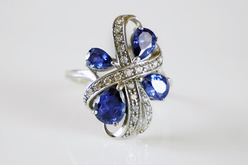 beautiful rich ring with blue tanzanite stones and  many white diamonds on white background