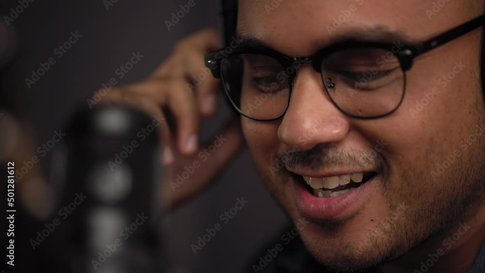 Wall mural close-up mouth of content creator man host streaming a podcast on laptop with headphones and condens