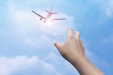 Low Angle View Of Hand Against Airplane and Blue Sky 