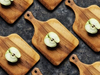 Pattern of slice of green apple on wooden cutting board on black concrete background. Granny smith. Spring fruits background.
