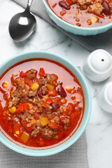 Tasty chili con carne on white marble table, flat lay