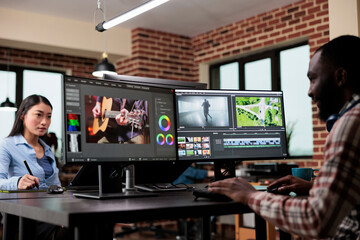 Post production department team leader editing movie footage using advanced technology software. Creative agency professional editor enhancing video film quality while sitting at desk.