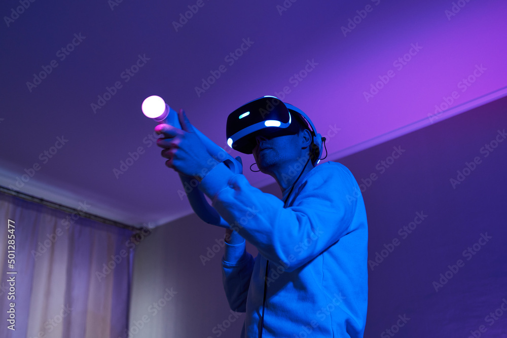 Wall mural man with virtual reality headset and joystic is playing game