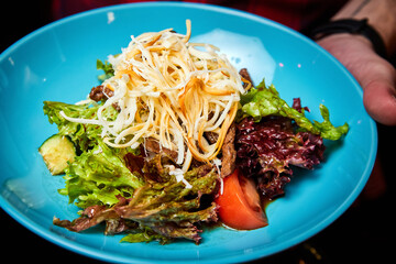 Warm salad with beef and smoked cheese. Close-up, selective focus.