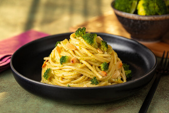 Pasta spaghetti alla chitarra with broccoli and  anchovy sauce and toasted almonds. Sun shine light.