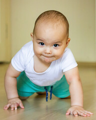 Sweet chubby baby learns to crawl on the floor
