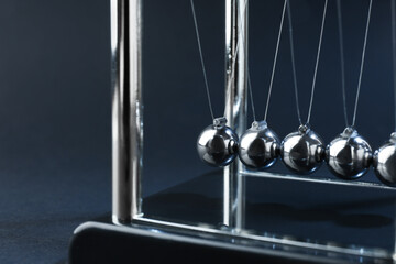 Newton's cradle on dark background, closeup. Physics law of energy conservation