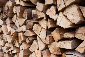 Fototapeta premium Fresh brown pile of tree stumps, woods structure. Wooden pattern background. Ecological heating, renewable energy sources. Ecological fuel. Sawmill, woodworking industry chopped firewood