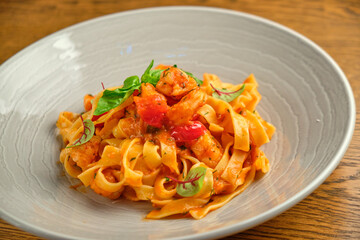 and fresh basil in a plate on a white wooden background. Selective focus.