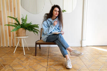 Portrait of a successful young european freelancer woman in casual clothes working in a home office or coworking space while sitting at her workplace. Portrait of a young female student studying remot