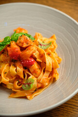 and fresh basil in a plate on a white wooden background. Selective focus.