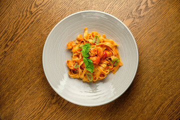 and fresh basil in a plate on a white wooden background. Selective focus.