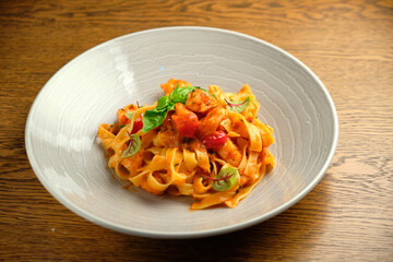 and fresh basil in a plate on a white wooden background. Selective focus.