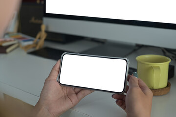 Close up view horizontal smartphone in woman hands. Blank screen for your text message or information content.
