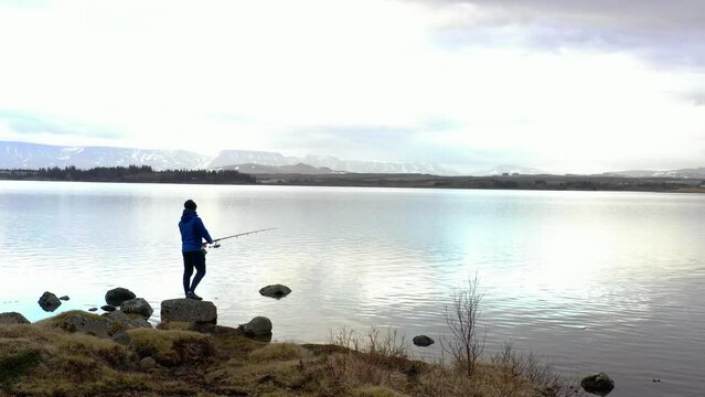 Man casting a fishing line outside the city in the cold spring morning backround footage