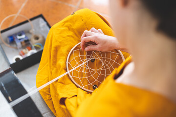 Woman making a dream catcher from threads