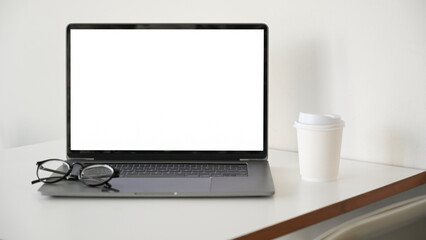 Notebook laptop computer white screen mockup on white office desk.
