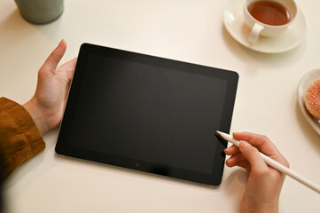 Female using digital tablet touchpad with stylus pen