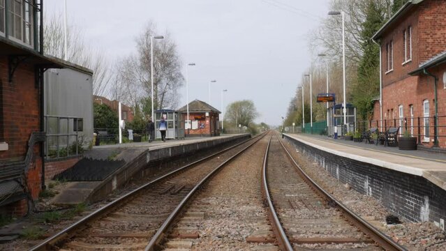 Teenagers walking through old village railway station in England