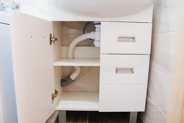 A siphon under the sink in the bathroom.