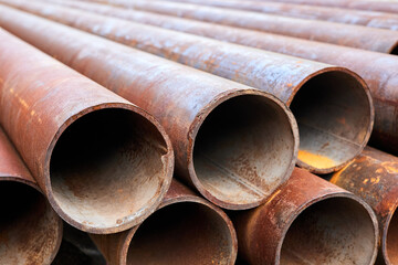 A group of Rusty metal pipes lying on the ground. Close-up, selective focus